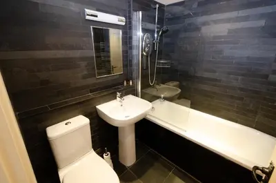 a bathroom with a sink and a toilet and a bath tub at Eltermere Inn in Elterwater