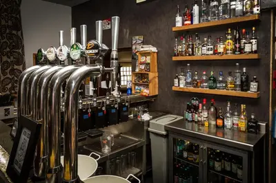 a bar with a lot of bottles of alcohol at Woolpack Inn in Eskdale
