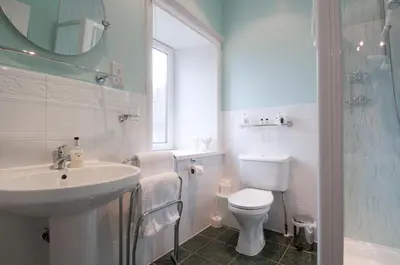 a white bathroom with a sink and a toilet at Douglas House in Castle Douglas