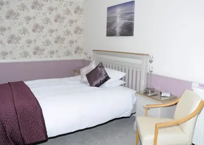a hotel room with a bed and a chair at Douglas House in Castle Douglas