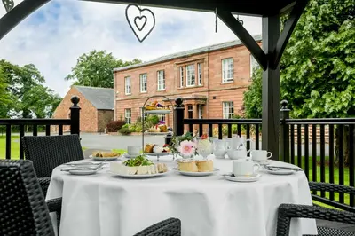 a table with a white table cloth with food on it at The Greenhill Hotel in Wigton