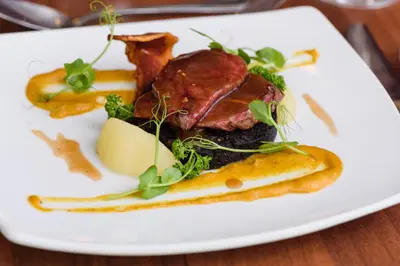a plate of food with meat and vegetables on a table at The Crown Hotel in Newton Stewart