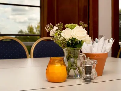 a vase filled with white roses sitting on a table at YHA Langdale in Ambleside