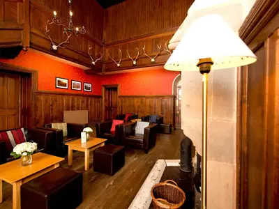 a living room with couches and tables and a lamp at YHA Langdale in Ambleside