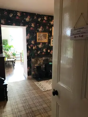 a room with a wall covered in flowers at Netherdene Country House Bed & Breakfast in Troutbeck