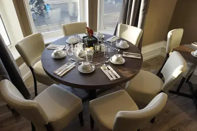 a dining room table with white chairs and a table and a table and chairsktop at Halvard Hotel in Douglas