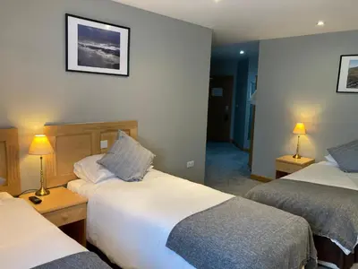 a hotel room with two beds and two lamps at Washington Central Hotel and Sleepwell Inn in Workington