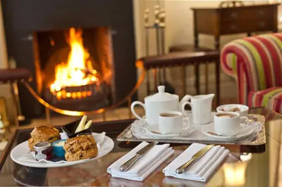 a table with two plates of food and a fireplace at Bridge Hotel in Buttermere