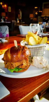 a sandwich and french fries on a plate on a table at Savoy Park Hotel in Ayr