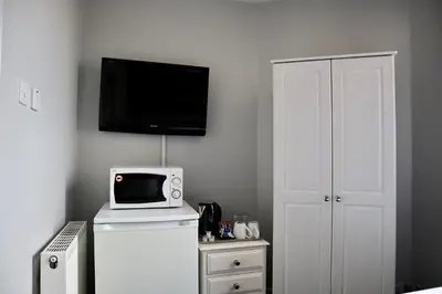 a microwave on top of a refrigerator in a room at Harbourside Hotel in Irvine