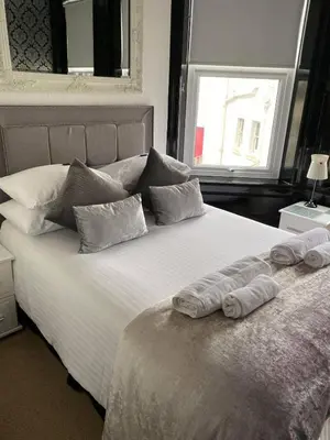 a bedroom with a large bed with two towels on it at Edelweiss Guest House in Douglas