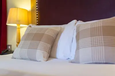 a bed with four pillows and a lamp on it at The Pennington Hotel in Ravenglass