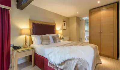 a bedroom with a large bed and a table with a lamp at The Pennington Hotel in Ravenglass