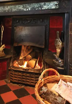 a fireplace with a fire inside of it at Boot & Shoe Inn in Greystoke