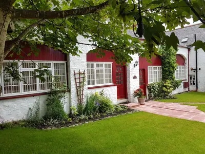 a house with a red door and a yard at Balmoral Hotel in Moffat