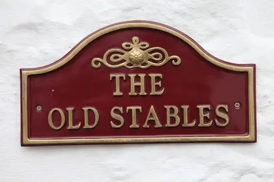 a sign for the old stables on a wall at Balmoral Hotel in Moffat