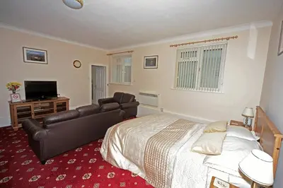 a bedroom with a large bed and a couch at Balmoral Hotel in Moffat
