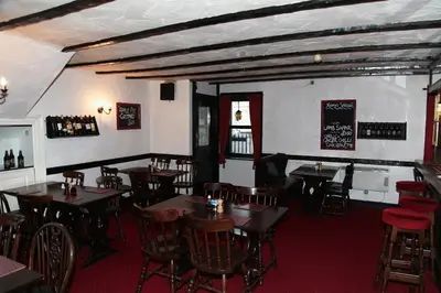 a restaurant with tables and chairs and a bar at Balmoral Hotel in Moffat
