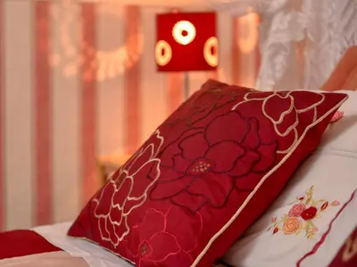 a red pillow sitting on top of a bed at The Warren Guest House in Carlisle