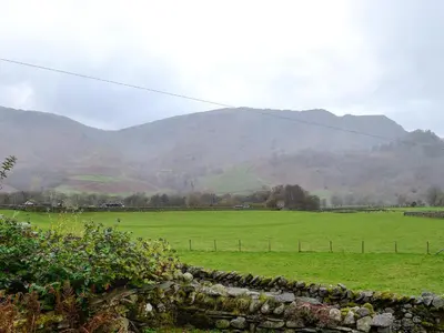 a green field with mountains in the background at Castle Howe in Rosthwaite