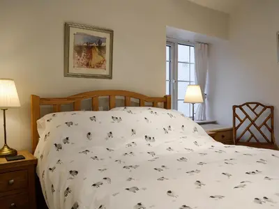 a bed with a comforter with dogs on it at Castle Howe in Rosthwaite