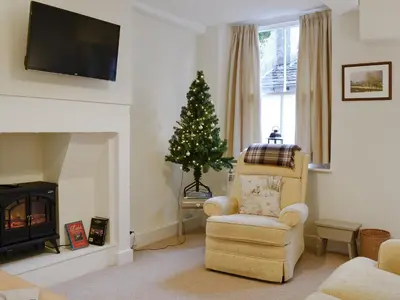 a living room with a christmas tree and a chair at Jasmine Cottage in Keswick