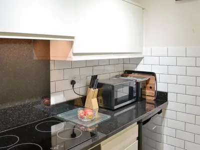 a kitchen with a microwave and a bowl of fruit on the counter at High Views in Keswick