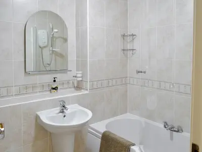 a bathroom with a sink and a toilet and a tub at High Views in Keswick