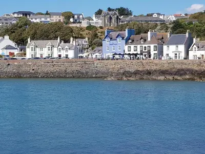 a group of houses on the shore of a body of water at The Waterfront in Portpatrick