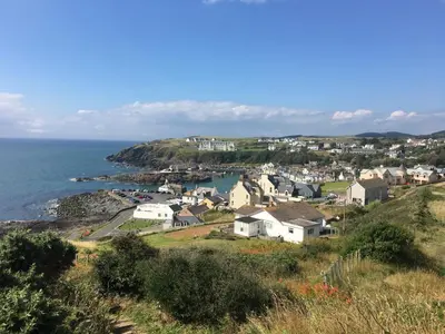 a small town on a hill next to the ocean at The Waterfront in Portpatrick