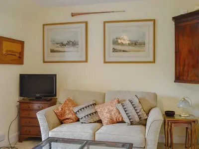 a living room with a couch and a tv at The Old Stables in Sorn
