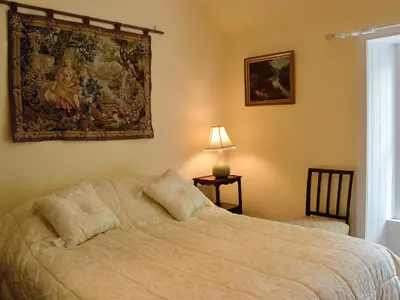 a bedroom with a bed with a painting on the wall at The Old Stables in Sorn