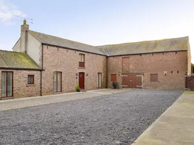 a large brick building with a driveway in front of it at Little Meadow in Dearham