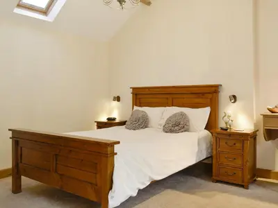 a bedroom with a large bed and two night stands at The Old Byre in Dearham
