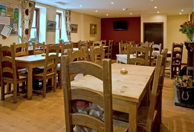 a dining room with wooden tables and chairs at New Dungeon Ghyll Hotel in Great Langdale