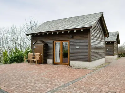 a small building with a patio with chairs on it at Harrison's Lodge - Uk1259 in Threlkeld