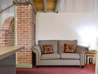 a couch sitting in a room with a brick wall at Harrison's Lodge - Uk1259 in Threlkeld