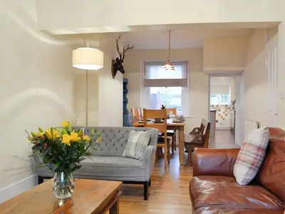 a living room with a couch and a vase of flowers on a table at Gilbert's Warrant in Keswick