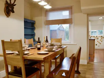 a dining room with a table with chairs and wine bottles at Gilbert's Warrant in Keswick