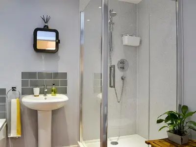 a bathroom with a shower and a sink at Porthole Cottage in Allonby