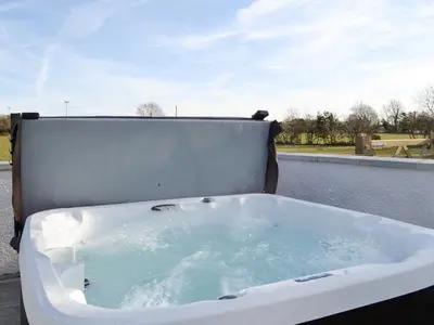 a bath tub filled with water on a balcony at Greengill Farm Holiday Cottage - Ukc2768 in Gilcrux