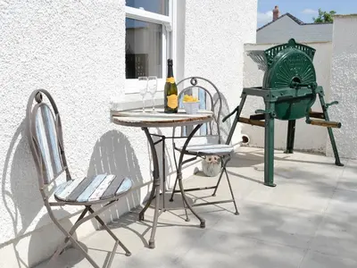 a table with a bottle of wine and two chairs at Greengill Farm Holiday Cottage - Ukc2768 in Gilcrux
