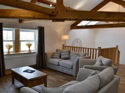 a living room with two couches and a table at Greengill Farm Holiday Cottage - Ukc2768 in Gilcrux