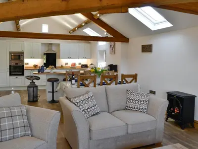 a living room with a couch and a kitchen at Greengill Farm Holiday Cottage - Ukc2768 in Gilcrux