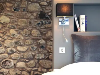 a bedroom with a stone wall with a lamp on it at 1692 Wasdale in Gosforth
