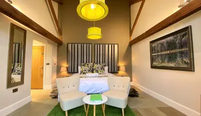 a bedroom with a bed with two chairs and a table at 1692 Wasdale in Gosforth