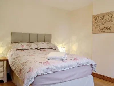 a bedroom with a bed with pink flowers on it at The Costins in Allonby