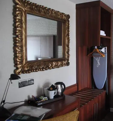 a mirror on a wall above a wooden desk at The Melbreak Hotel in Great Clifton