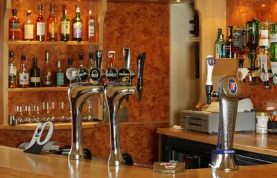 a bar with two silver faucets on a counter at Cressfield Country House Hotel in Ecclefechan