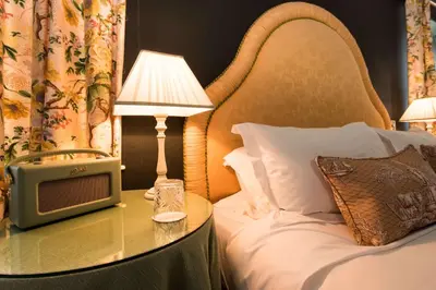 a bed with a table with a television and a lamp at Cavens Country House, DINNER INCLUSIVE! in Kirkbean